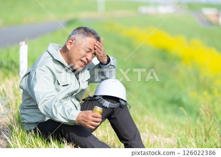A senior supervisor taking a break with a can of coffee in hand 126022386