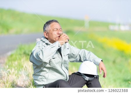 A senior supervisor taking a break with a can of coffee in hand 126022388