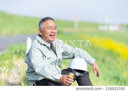 A senior supervisor taking a break with a can of coffee in hand 126022392