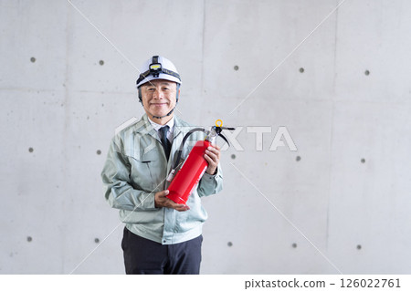 A middle-aged man holding a fire extinguisher and calling for safety measures 126022761