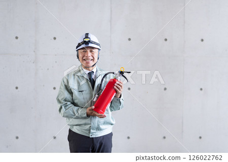 一名中年男子手持滅火器,呼籲採取安全措施 一名中年男子手持滅火器,呼籲採取安全措施 126022762