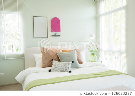 Modern bedroom with green and pink pillows on bed. Stylish bedroom interior design. Modern bedroom with green and pink pillows on bed. Stylish bedroom interior design. 126023287