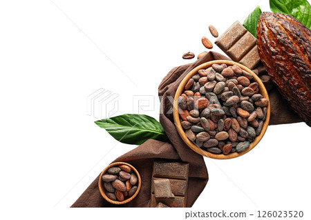 Various cacao beans and chocolate pieces are displayed on a brown cloth alongside green leaves, isolated on white, PNG 126023520