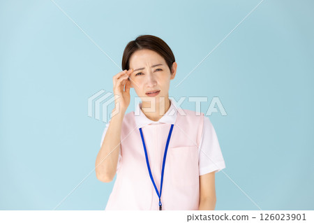 Woman in apron, caregiver, nursery teacher, medical, headache 126023901
