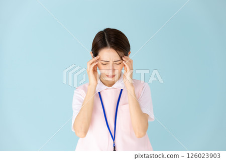 Woman in apron, caregiver, nursery teacher, medical, headache Woman in apron, caregiver, nursery teacher, medical, headache 126023903