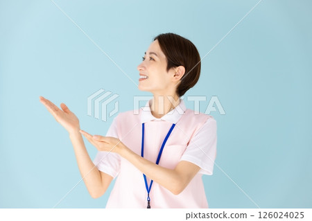 Woman in apron, caregiver, nursery teacher, medical, hand-waving Woman in apron, caregiver, nursery teacher, medical, hand-waving 126024025