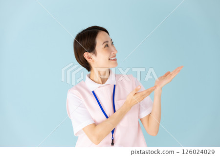 Woman in apron, caregiver, nursery teacher, medical, hand-waving Woman in apron, caregiver, nursery teacher, medical, hand-waving 126024029