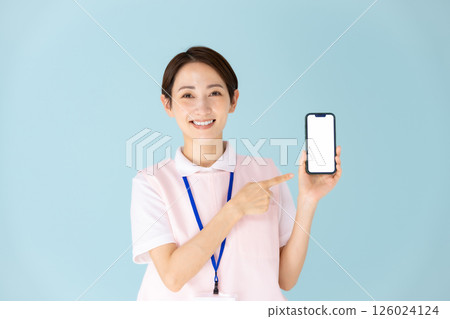 Woman in apron, caregiver, nursery teacher, medical, smartphone Woman in apron, caregiver, nursery teacher, medical, smartphone 126024124