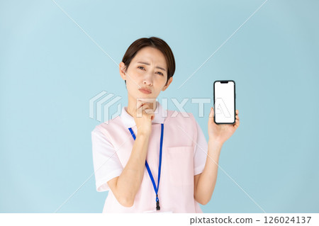 Woman in apron, caregiver, nursery teacher, medical, smartphone Woman in apron, caregiver, nursery teacher, medical, smartphone 126024137