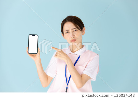 Woman in apron, caregiver, nursery teacher, medical, smartphone Woman in apron, caregiver, nursery teacher, medical, smartphone 126024148