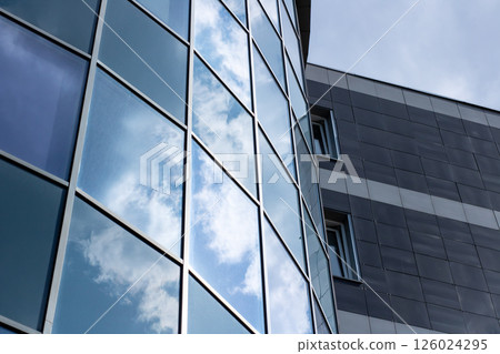 The sky beautifully reflects in the windows of a tall building 126024295