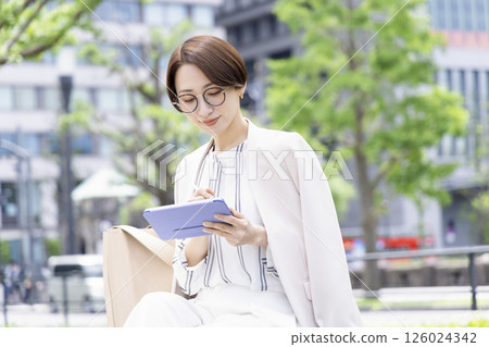 在平板電腦上寫作的女商人 在平板電腦上寫作的女商人 126024342