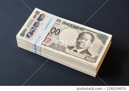 A stack of 10,000 yen bills on a black table 126024650