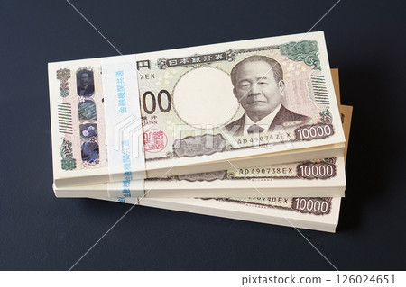 A stack of 10,000 yen bills on a black table A stack of 10,000 yen bills on a black table 126024651