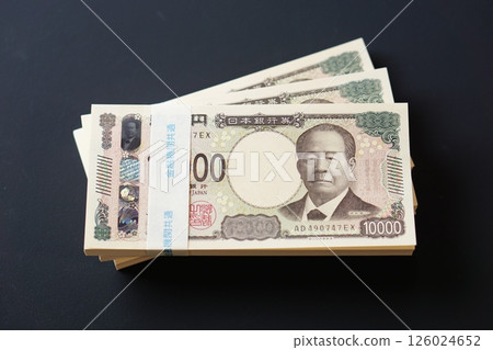 黑色桌子上放著一疊 10,000 日元鈔票 黑色桌子上放著一疊 10,000 日元鈔票 126024652