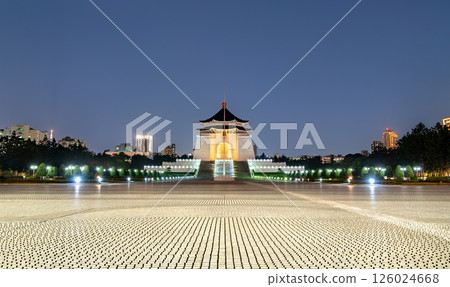 The Chiang Kai-shek Memorial Hall in Taipei, Taiwan, is illuminated at night with dramatic lighting, viewed from Liberty Square across the patterned ground tiles, symbolizing national heritage and 126024668