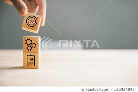Hand skillfully arranging wood block stacking to depict a business strategy and Action plan, targeting the business concept. This image represents business development and growth. Hand skillfully arranging wood block stacking to depict a business strategy and Action plan, targeting the business concept. This image represents business development and growth. 126024842