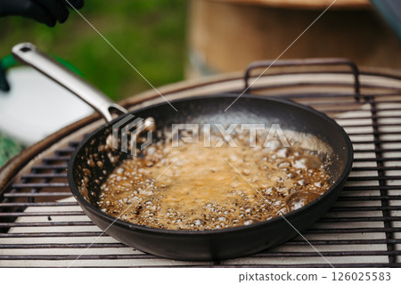 Melting brown sugar and butter in pan for dessert. 126025583