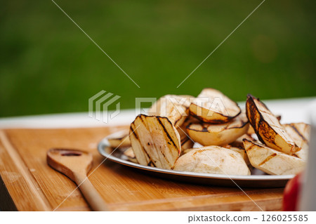 Grilled apple slices with char marks on serving plate. 126025585