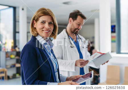 Pharmaceutical rep meeting with healthcare professional to discuss new drugs 126025638