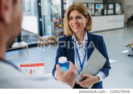 Pharmaceutical rep meeting with healthcare professional to discuss new drugs 126025646