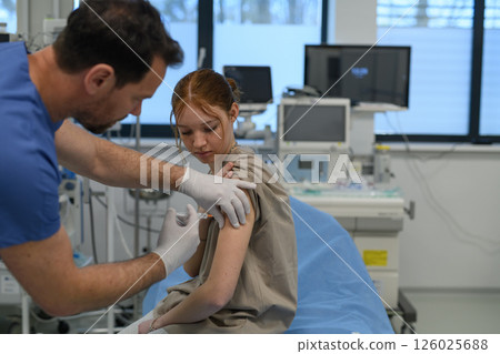 Vaccination of teenage girl during routine health checkup at hospital. 126025688