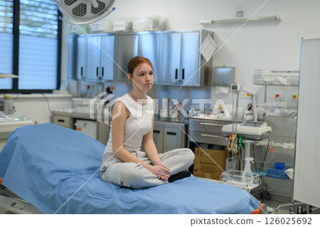 Teenage girl waiting for medical examination in hospital. Teenage girl waiting for medical examination in hospital. 126025692