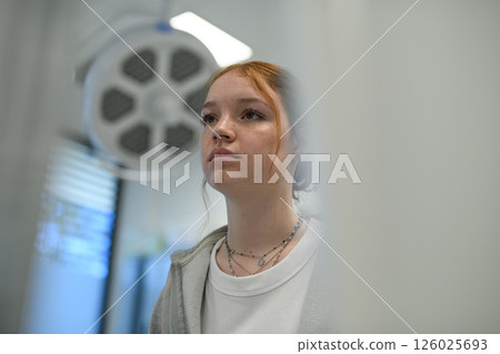 Teenage girl waiting for medical examination in hospital. Teenage girl waiting for medical examination in hospital. 126025693