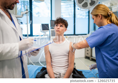 Vaccination of teenage boy during routine health checkup at hospital 126025735