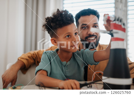 Father teaching son about STEM, robotics, and discussing technology. 126025760