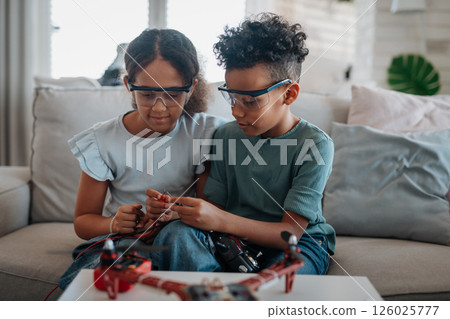 Kids building their first homemade robot at home. 126025777