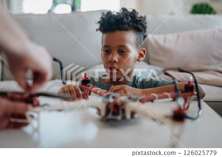 Father teaching son about STEM, robotics, and discussing technology. 126025779