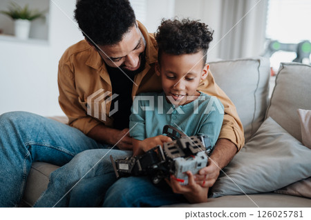 Father and son exploring STEM, robotics, and technology together. 126025781