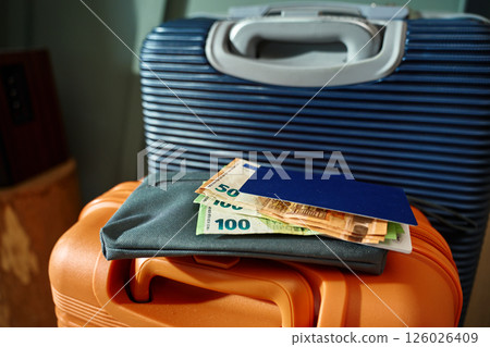 Passport and cash money on suitcase. Preparation for trip Passport and cash money on suitcase. Preparation for trip 126026409