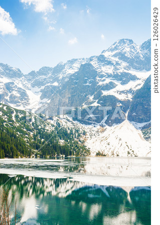 landscape with lake in tatra mountains of poland in spring. alpine scenery under blue sky. outdoor adventure and vacation season on morskie oko landscape with lake in tatra mountains of poland in spring. alpine scenery under blue sky. outdoor adventure and vacation season on morskie oko 126026429