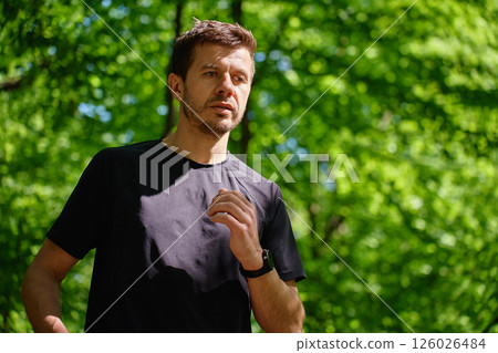 Man running on forest trail in summer morning. Healthy lifestyle jogging Man running on forest trail in summer morning. Healthy lifestyle jogging 126026484