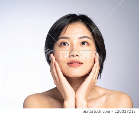 一位年輕女子雙手放在臉上的美麗形象 126027212