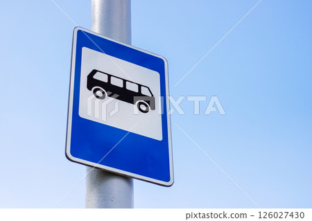 A blue and white bus stop sign affixed to a tall pole 126027430