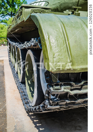 Close-up detail of military tank tracks and mudguard, olive green armored vehicle treads and side armor plating, heavy military equipment transport system Close-up detail of military tank tracks and mudguard, olive green armored vehicle treads and side armor plating, heavy military equipment transport system 126028156