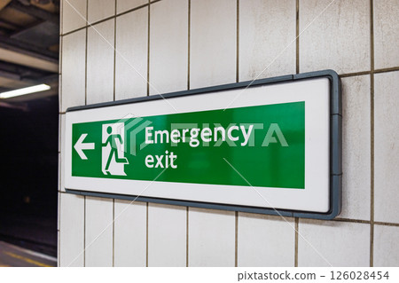 Green Emergency Exit Sign in Underground Subway Station with Directional Arrow Green Emergency Exit Sign in Underground Subway Station with Directional Arrow 126028454