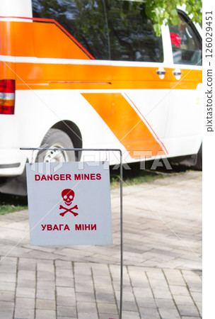A sign with the inscription Danger Mines and a translation into Ukrainian, which is installed, miners, sappers and rescuers. 126029451