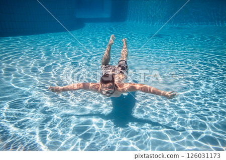Teenager underwater in a swimming pool... 126031173