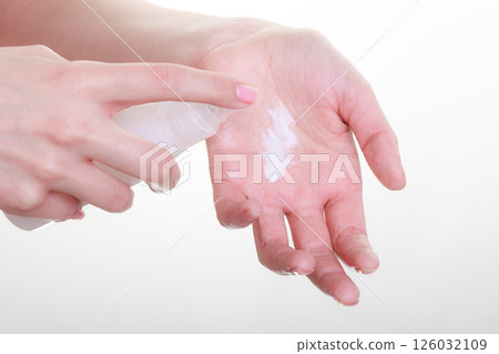 Woman putting white cream on hand Woman putting white cream on hand 126032109