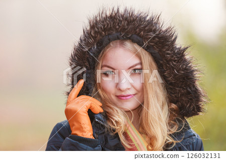 Portrait pretty smiling woman in jacket with hood. 126032131