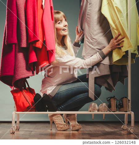 Woman choosing clothes to wear in mall or wardrobe Woman choosing clothes to wear in mall or wardrobe 126032148