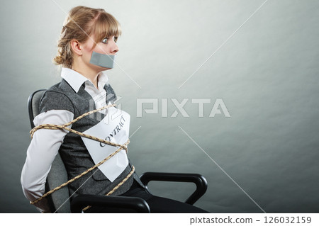 Businesswoman bound by contract with taped mouth. 126032159