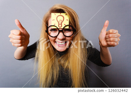 Woman having light bulb mark on forehead thinking Woman having light bulb mark on forehead thinking 126032442