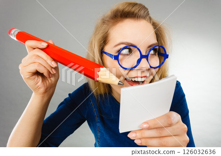 Crazy woman holds big pencil in hand 126032636