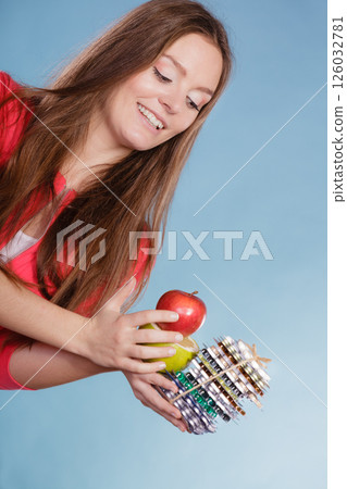 Woman holding pills and fruits. Health care 126032781