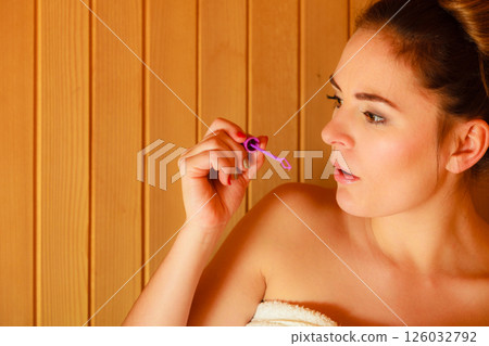 woman relaxing in sauna room blowing soap bubbles woman relaxing in sauna room blowing soap bubbles 126032792